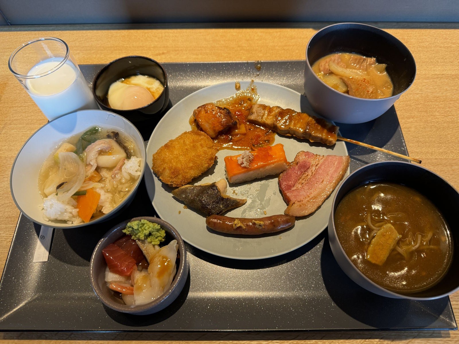 朝食のトレー。小鉢がいくつかと、揚げ物やハムの載った皿