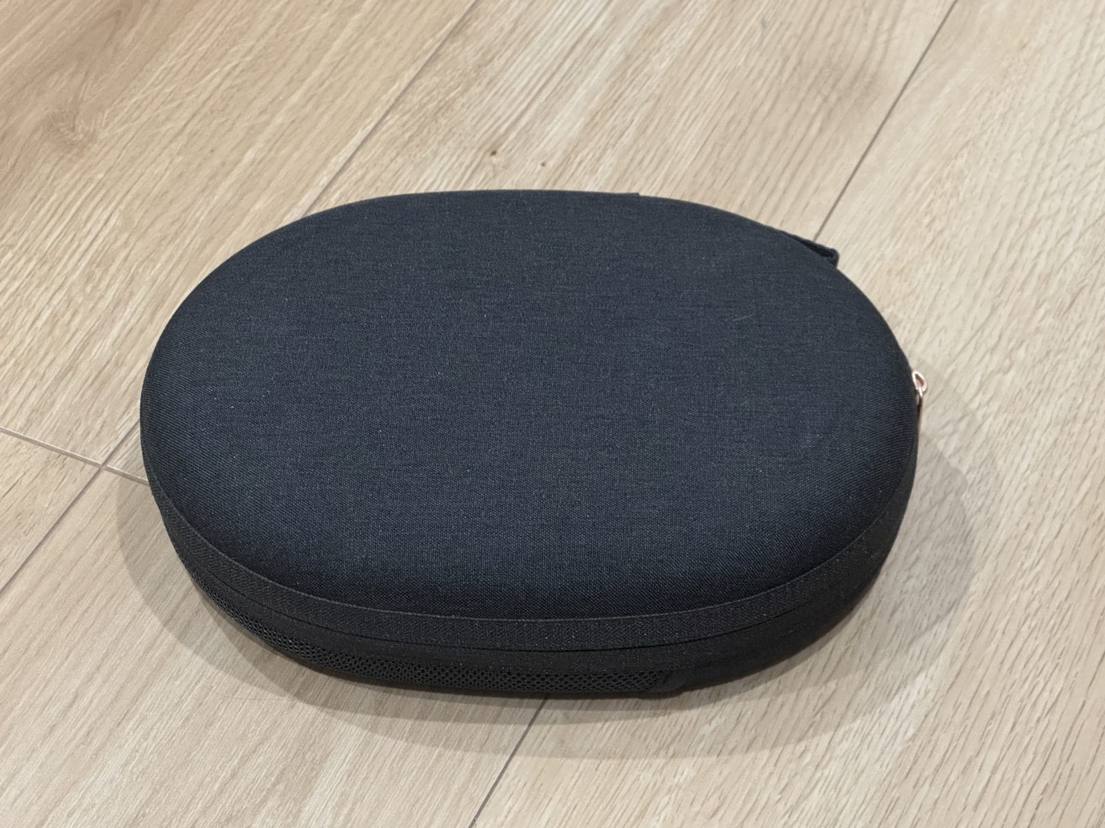 ふたを閉じた黒い楕円形のハードケース。床に置いた状態
