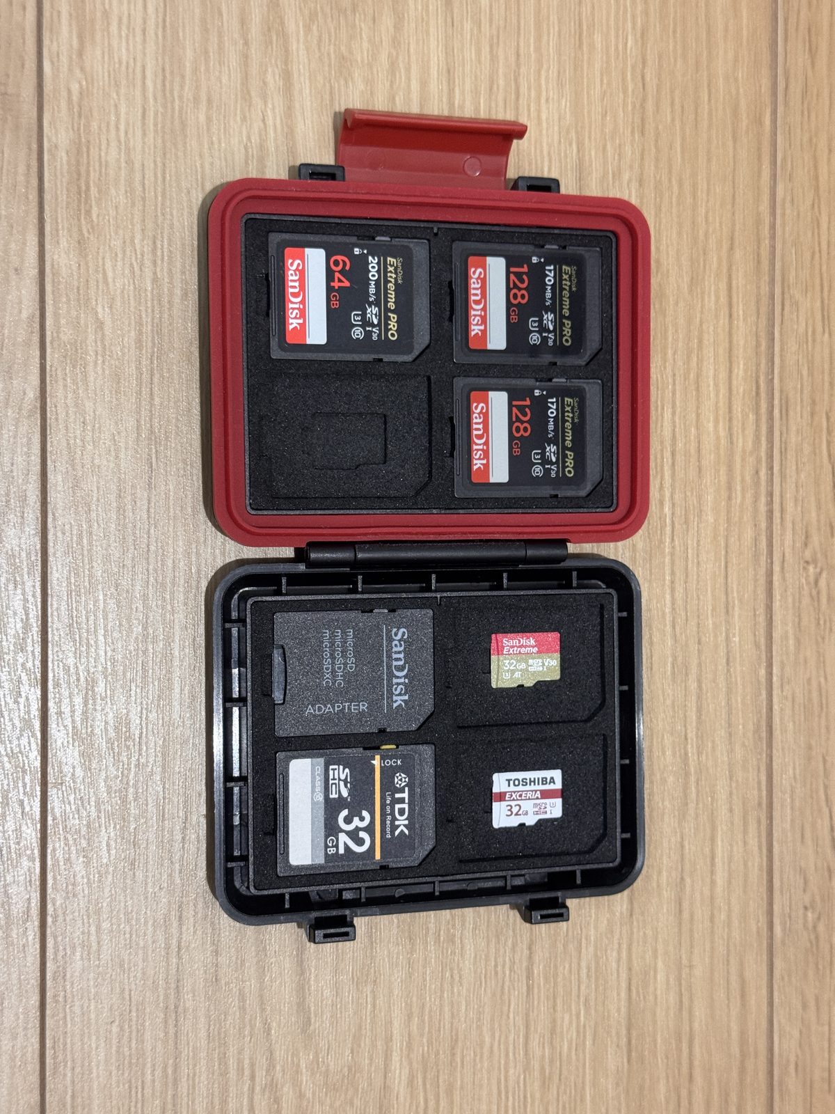 開いたメモリーカードケース。SanDisk Extreme PROの64GBと128GB、microSD、TDKとTOSHIBAの32GBが並んでいる