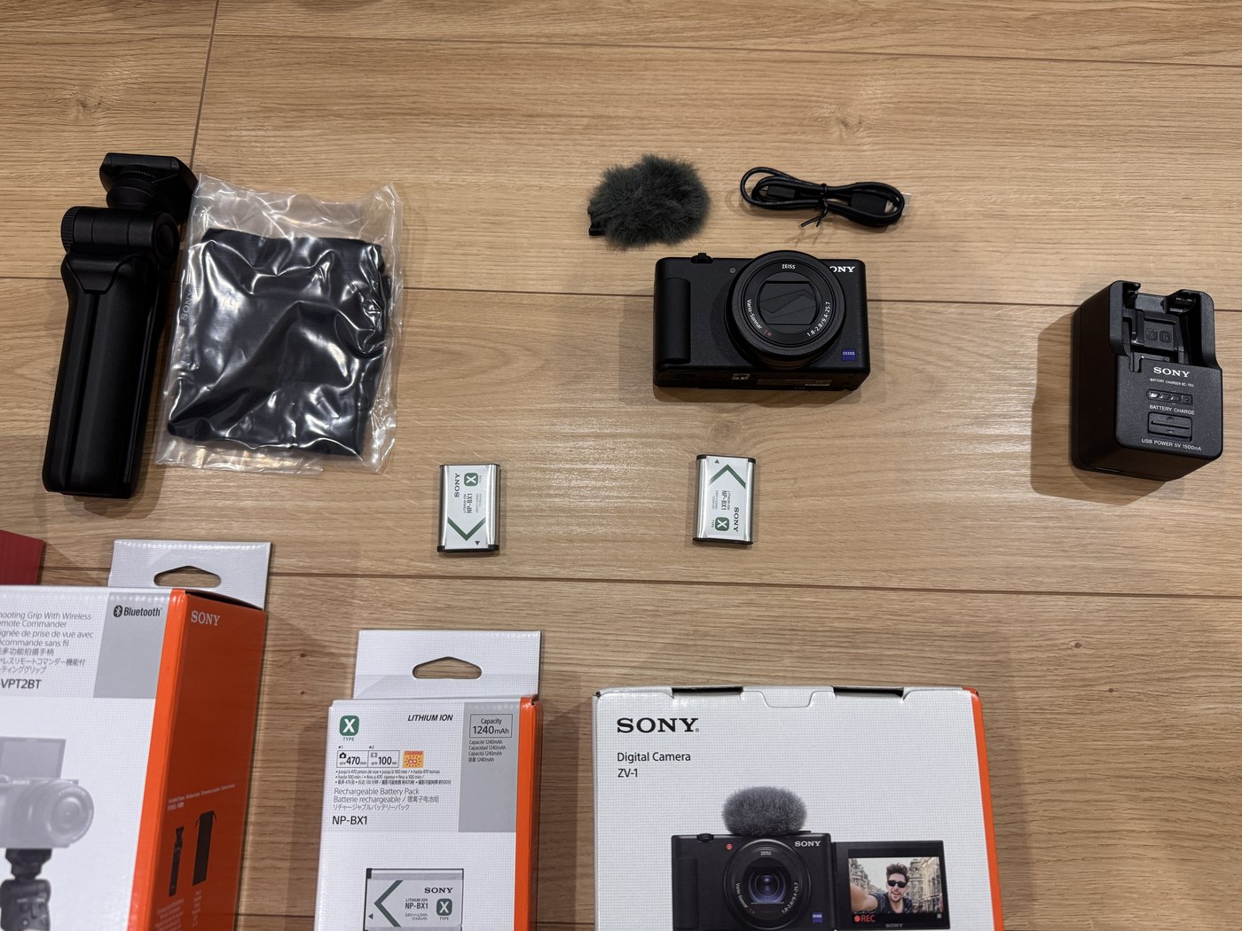 床に並べたSONYのカメラ本体、グリップ、マイク、予備の電池2個、充電器、ケーブル