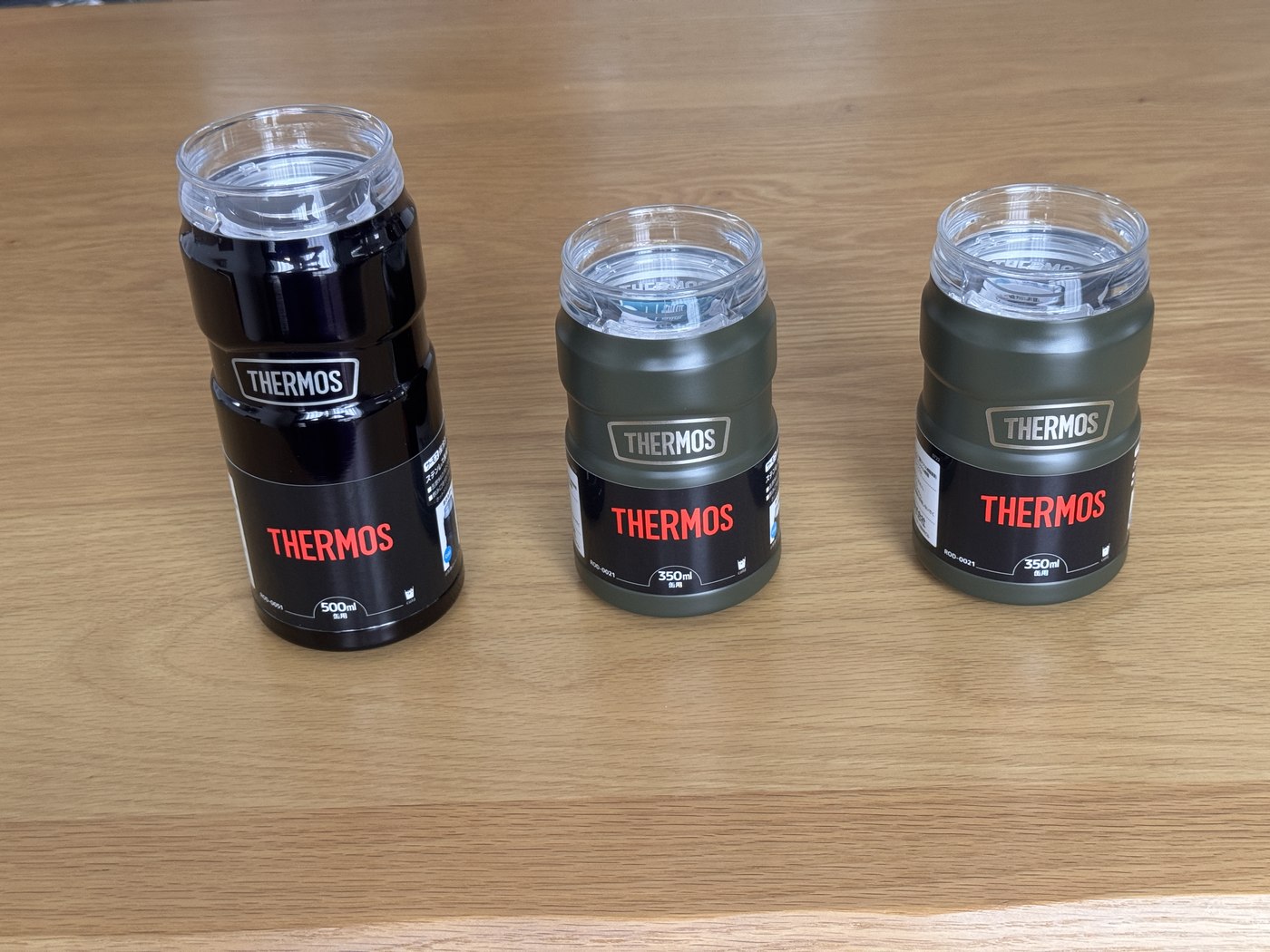 サーモスの保冷缶ホルダー3本。左が500ml缶用の黒、右2本が350ml缶用のカーキ。透明な飲み口が付いている