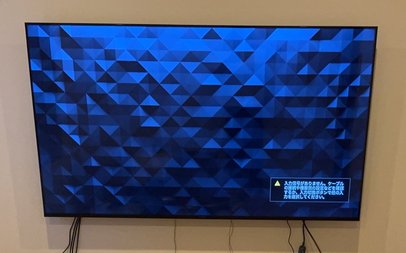 壁に取り付けた75型の4K液晶テレビ。画面には入力信号がありませんという案内が出ている